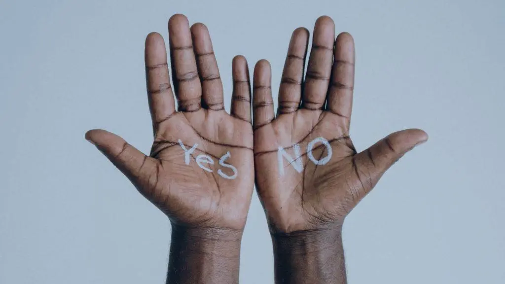 Two hands, writing yes or no